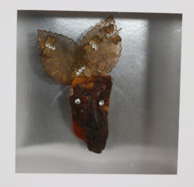 Urve Küttner. Uranos, 2016-2018 a. Hõbe, merevaik, ready-made lisandid ja Swarowski kristallid. 5,5x9 cm